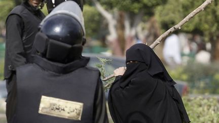 Une Egyptienne affronte les forces de l'ordre place Tahrir au Caire (Egypte), le 19 novembre 2011. (MOHAMED ABD-EL-GHANY / REUTERS)