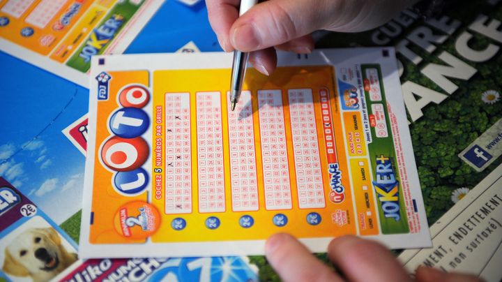 Un homme remplit une grille de Loto, &agrave; Paris,&nbsp;le 12 avril 2012. (FRANCK FIFE / AFP)