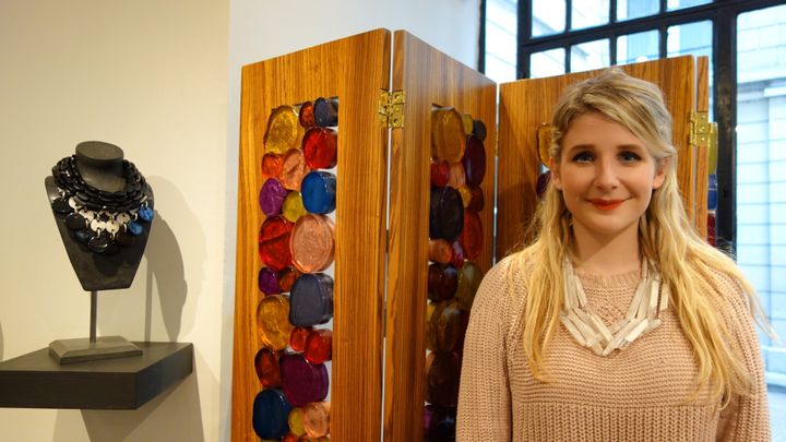 Emma Denaive pose devant un panneau en bois avec inclusion de pièces de résine 
 (Corinne Jeammet)