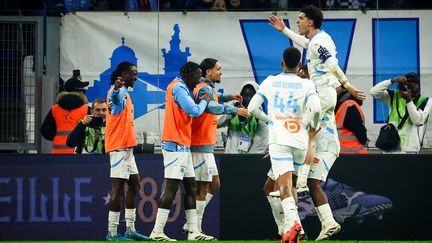 Luis Henrique, Leonardi Balerdi et Elye Wahi célébrant un but avec les remplaçants lors de la rencontre de Ligue 1 entre Marseille et Monaco, le 1er décembre 2024 au Vélodrome. (CLEMENT MAHOUDEAU / AFP)