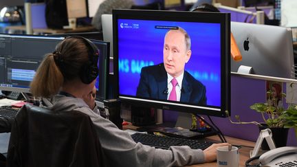 Une femme regarde une intervention en direct de Vladimir Poutine, le 15 juin 2017. (RAMIL SITDIKOV / SPUTNIK / AFP)