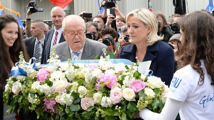 Marine Le Pen, pr&eacute;sidente du Front national, et son p&egrave;re Jean-Marie Le Pen, pr&eacute;sident d'honneur du parti, d&eacute;posent une gerbe de fleurs au pied de la statue de&nbsp;Jeanne&nbsp;d'Arc, &agrave; Paris. (PIERRE ANDRIEU / AFP)