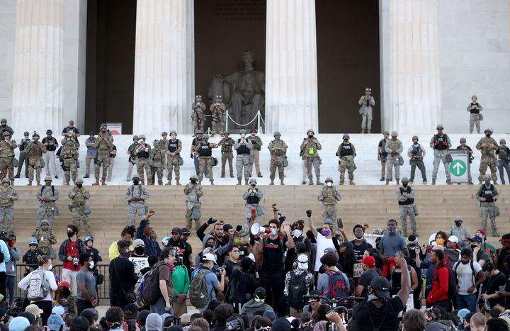 Des membres de la Garde nationale de Washington se tiennent sur les marches du Lincoln Memorial devant une foule de manifestants rassemblés le 2 juin 2020 après la mort de l'Afro-Américain George Floyd. (WIN MCNAMEE / GETTY IMAGES NORTH AMERICA / AFP)