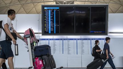 Des voyageurs à l'aéroport international de Hong Kong, en Chine, le 7 juillet 2022. (VERNON YUEN / NURPHOTO / AFP)