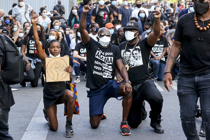 Des manifestants posent un genou à terre,&nbsp;devant le tribunal de grande instance de Paris, lors d'une manifestation contre les violences policières, le 2 juin 2020. (SEBASTIEN MUYLAERT / MAXPPP)