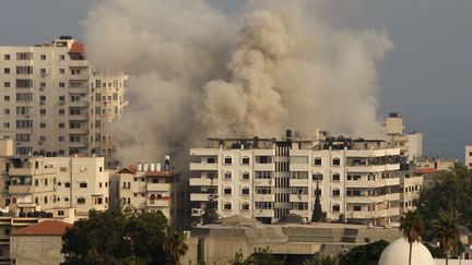 De la fum&eacute;e s'&eacute;chappe d'un b&acirc;timent de la bande de Gaza, apr&egrave;s de nouveaux raids isra&eacute;liens, le 22 juillet 2014.&nbsp; (AHMED ZAKOT / REUTERS)