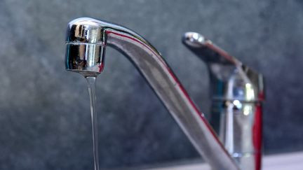 L'eau coule à faible pression d'un robinet dans une maison à Clonas-sur-Varèze (Isère), placée en situation d'alerte renforcée sécheresse, le 8 août 2022. (ROMAIN DOUCELIN / HANS LUCAS / AFP)