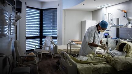 Un chirurgien discute avec un&nbsp;patient, à l'hôpital Saint-Louis, à Paris, le 28 mai 2020. (MARTIN BUREAU / AFP)