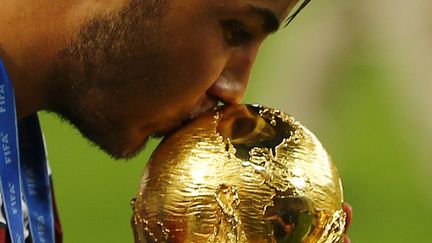 &nbsp; (Le buteur allemand, Mario Gotze, embrasse le trophée de la Coupe du Monde © Reuters - Damir Sagolj)