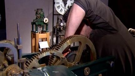 Un artisan règle une vieille horloge au musée du temps de Besançon
 (France3culturebox)