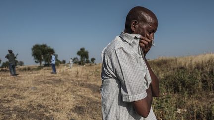 Un homme en larmes&nbsp;devant une fosse commune où sont entassés les corps d'au moins 20 victimes d'un massacre qui a eu lieu près de Mai Kadra (Ethiopie), le 9 novembre 2020. (EDUARDO SOTERAS / AFP)