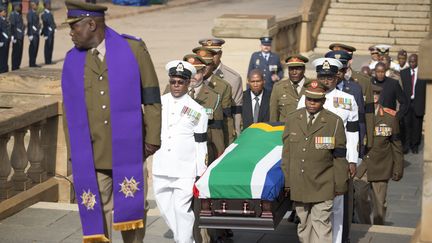 Des militaires am&egrave;nent le cercueil de Nelson Mandela &agrave; l'int&eacute;rieur de l'Union Buildings, le si&egrave;ge du gouvernement&nbsp;sud-africain, &agrave; Pretoria, le 11 d&eacute;cembre 2013. (MARCO LONGARI / AFP)