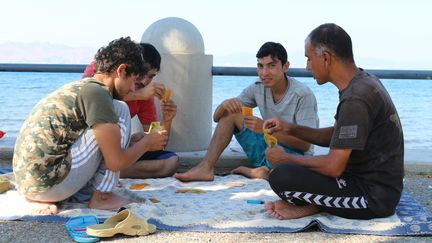 Les journ&eacute;es sont longues sur l'&icirc;le de Kos (Gr&egrave;ce) et il n'y a souvent qu'un seul repas. Alors, pour tuer le temps, certains migrants jouent aux cartes pendant que d'autres se baignent pour se rafra&icirc;chir. (BENOIT ZAGDOUN / FRANCETV INFO)