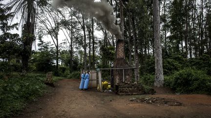 Des soignants brûlent du matériel ayant servi à soigner des patients atteints du virus Ebola à Mangina, en République démocratique du Congo, le 21 août 2018. (JOHN WESSELS / AFP)