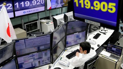 Un trader surveille les conséquences du rejet du référendum italien depuis la bourse de Tokyo (Japon), le 5 décembre 2016. (TORU HANAI / REUTERS)