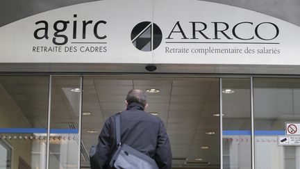 Un homme entre au si&egrave;ge des organismes de retraites compl&eacute;mentaires, Agirc et Arrco, le 16 octobre 2012 &agrave; Paris. (KENZO TRIBOUILLARD / AFP)