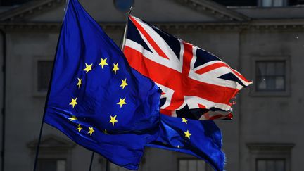 Le drapeau européen et l'Union Jack flottent devant le Parlement britannique, à Londres, le 14 mars 2019. (BEN STANSALL / AFP)