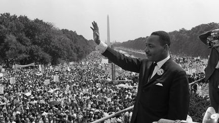 Martin Luther King (au centre) salue ses partisans le 28 août 1963 sur le centre commercial de Washington DC (Washington Monument en arrière-plan) lors de la « "Marche sur Washington", où il a prononcé son célèbre discours "I Have a Dream". (- / AFP)