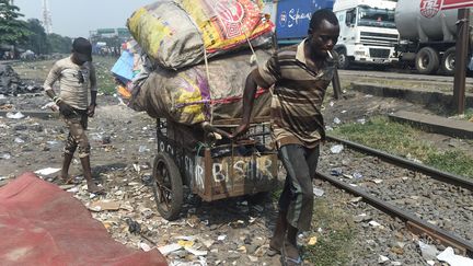 Un chiffonnier nigérian transporte des vêtements dans une charrette à Badiya, à Lagos, le 22 janvier 2019. Le pays&nbsp;détient le triste record du plus grand nombre de personnes vivant dans l'extrême pauvreté, selon World Poverty Clock. (PIUS UTOMI EKPEI / AFP)