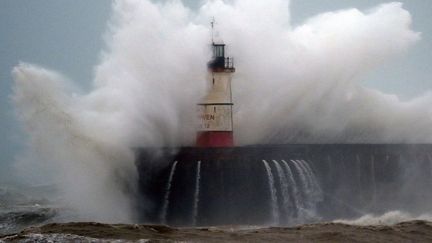 Une vague submerge le phare de Newhaven, dans le sud de l'Angleterre, le 9 février 2020. (GLYN KIRK / AFP)