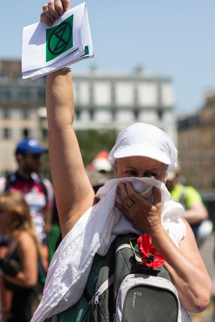 Une manifestante cache sa figure, à Paris le 28 juin 2019. (RAPHAEL KESSLER  / HANS LUCAS / AFP)