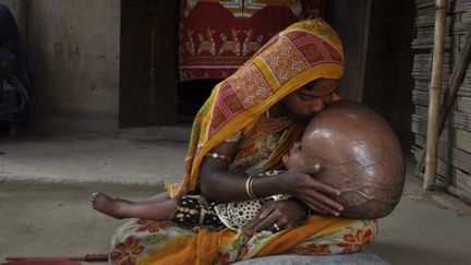 Roona, 18 mois, dans les bras de sa m&egrave;re, dans leur village de l'Etat de Tripura, en Inde, le 13 avril 2013.&nbsp; (ARINDAM DEY / AFP)