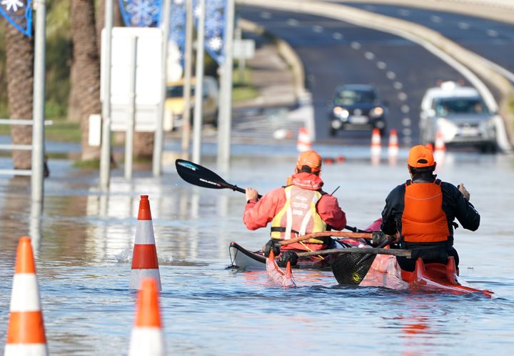 Deux hommes font du kayak sur une route inondée à Palavas-les-Flots (Hérault), le 23 novembre 2019.&nbsp; (PASCAL GUYOT / AFP)