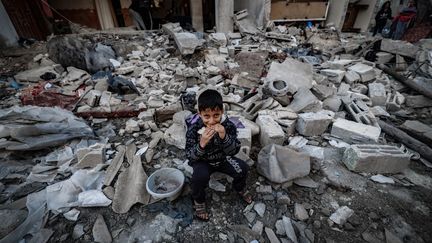 A child on the ruins of a building hit by Israeli strikes in Rafah, in the Gaza Strip, December 29, 2023. (AFP)