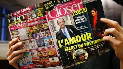 Un homme lit le magazine "Closer" du 10 janvier 2014 affirmant que Fran&ccedil;ois Hollande entretient une liaison avec l'actrice Julie Gayet. (THOMAS COEX / AFP)