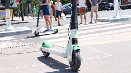 Une trottinette électrique en libre service (de la marque Lime) sur un trottoir, juste devant un passage piéton et une piste cyclable,&nbsp;le 6 juillet 2019 à Paris. (AURÉLIEN ACCART / RADIO FRANCE)