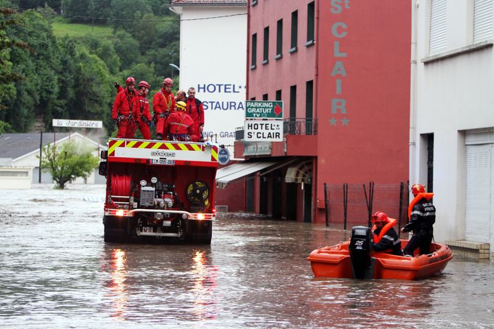 Des pompiers patrouillent pour porter secours &agrave; des habitants dans Lourdes (Hautes-Pyr&eacute;n&eacute;es) inond&eacute;e, le 18 juin 2013. (LAURENT DARD / AFP)