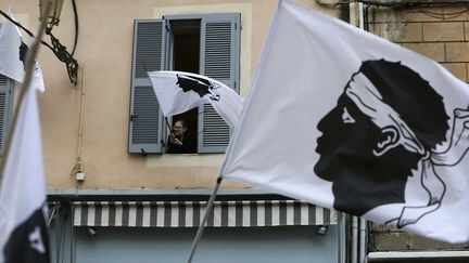 Une habitante de Bastia agite le drapeau corse en soutien à une manifestation. (PASCAL POCHARD-CASABIANCA / AFP)