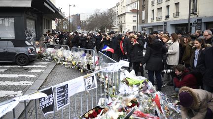 Des dizaines de personnes rendent hommage aux victimes de la prise d'otages dans l'&eacute;picerie cacher de la porte de Vincennes, &agrave; Paris,&nbsp;le 12 janvier 2015. (MARTIN BUREAU / AFP)