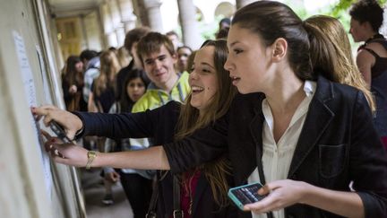 Des lyc&eacute;ens d&eacute;couvrent les r&eacute;sultats du bac, le 5 juillet 2013, au lyc&eacute;e Aragon, &agrave; Paris. (FRED DUFOUR / AFP)