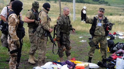 Un militant prorusse tient une peluche sur le site du crash de l'avion du vol MH17 &agrave;&nbsp;Grabove (Ukraine), le 18 juillet 2014. (DOMINIQUE FAGET / AFP)