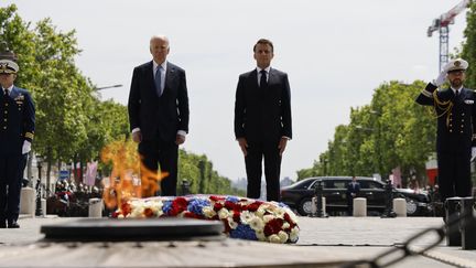 Le président français, Emmanuel Macron, et le président américain, Joe Biden, devant la tombe du Soldat inconnu sous l'Arc de Triomphe, à Paris, le 8 juin 2024. (LUDOVIC MARIN / AFP)