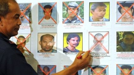 Le directeur général de la police philippine, Jesus Versoza, le 25 février 2010, signale sur un tableau l'arrestation de Mujibar Alih Amon, un membre d'Abu Sayyaf. (AFP PHOTO/TED ALJIBE)