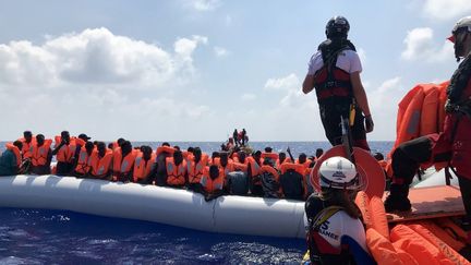 Les membres d'équipage de l'Ocean Viking, le samedi 10 août, alors qu'ils portent secours aux migrants embarqués sur un matelas pneumatique. (ANNE CHAON / AFP)