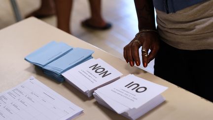 Une électrice s'apprête à se prononcer sur l'indépendance de la Nouvelle-Calédonie, lors du précédent scrutin&nbsp;organisé le 4 novembre 2018 à Nouméa. (THEO ROUBY / AFP)