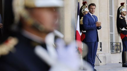 Le président Emmanuel Macron&nbsp;en haut des marches&nbsp;du palais de l'Élysée à Paris, le 29 août 2022. (LUDOVIC MARIN / AFP)