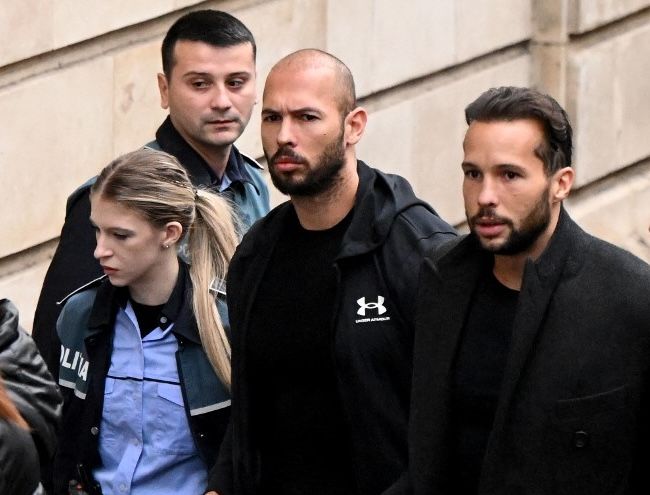 Brothers Andrew and Tristan Tate (center and right), arrive at a courthouse in Bucharest, Romania, on January 10, 2023. (DANIEL MIHAILESCU / AFP)