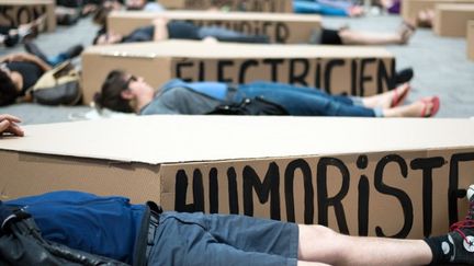 Les manifestants sur le sol à côté de boîites en carton en forme de cercueil avec les noms des différentes professions et festivals, à Marseille, le 18 juin 2014
 (BERTRAND LANGLOIS / AFP)