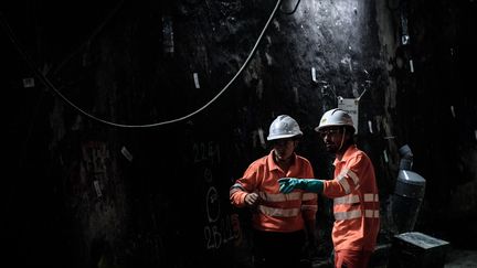 Deux personnes travaillent dans un tunnel de métro à la station Saint-Michel, à Paris, le 29 juin 2016, pendant les travaux de rénovation du RER C. (PHILIPPE LOPEZ / AFP)