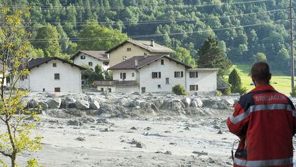 Un secouriste devant le village de Bondo (sud-est de la Suisse), balayé par un glissement de terrain, le 23 août 2017.&nbsp; (GIANCARLO CATTANEO / AFP)