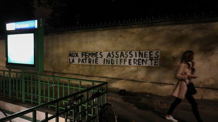 Un groupe qui dénonce les féminicides à coller ce message "Aux femmes assassinées, la patrie indifférente" près du métro Varennes (7e arrondissement de Paris) vendredi 6 septembre. (LUDOVIC MARIN / AFP)