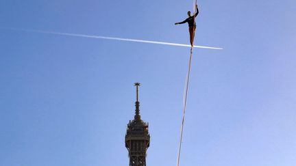 Le funambule Nathan Paulin sur une corde entre la tour Eiffel et la place du Trocadéro, à Paris, le 9 décembre 2017. (JACQUES DEMARTHON / AFP)