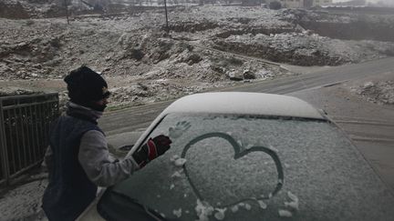 Un jeune gar&ccedil;on dessine sur un pare-brise enneig&eacute;s, dans le village de Madjal Shams, sur le plateau du Golan, le 8 janvier 2013.&nbsp; (AMMAR AWAD / REUTERS )