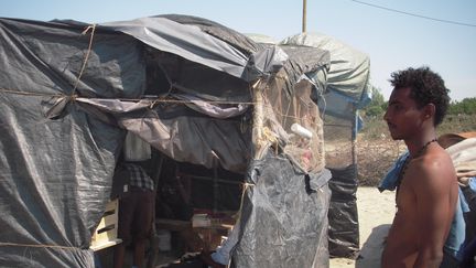 Fathi, un jeune r&eacute;fugi&eacute; soudanais, mercredi 1er juillet &agrave; Calais (Pas-de-Calais), devant la tente o&ugrave; il partage une cuisine avec une quinzaine d'autres migrants. (LOUIS BOY / FRANCETV INFO)