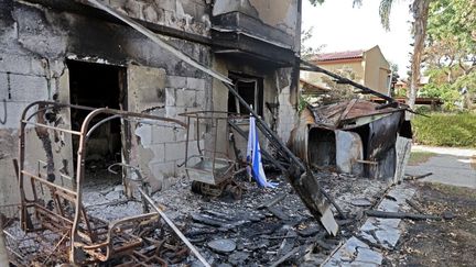 Une maison incendiée dans le kibboutz israélien Beeri, le long de la frontière avec la bande de Gaza, à la suite d'une attaque de militants palestiniens le 7 octobre. Cette photo a été prise le 22 octobre 2023 lors d'un convoi organisé par l'armée israélienne. (THOMAS COEX / AFP)