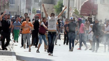 Des jeunes affrontent des policiers, le 19 mai 2013 &agrave;&nbsp;Ettadhamen, un quartier pauvre de la banlieue de Tunis (Tunisie). (KHALIL / AFP)